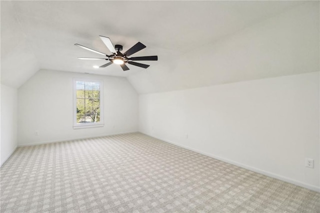 additional living space featuring vaulted ceiling, light carpet, and ceiling fan