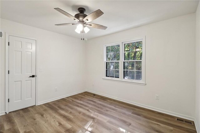 spare room featuring ceiling fan, wood finished floors, and baseboards
