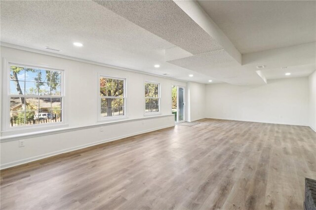 interior space with a textured ceiling and light hardwood / wood-style floors