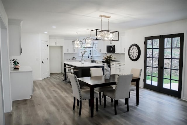 dining space with recessed lighting, a wealth of natural light, wood finished floors, and baseboards