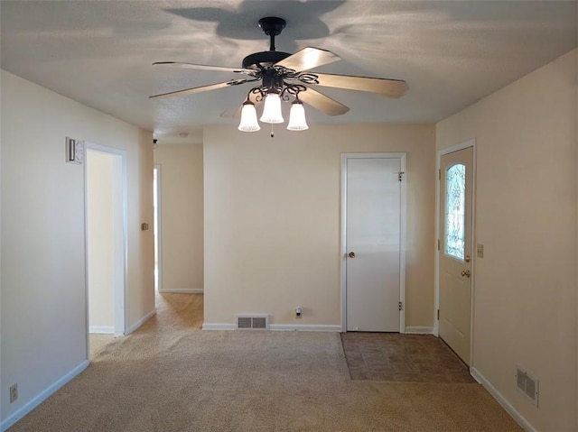 carpeted spare room featuring ceiling fan