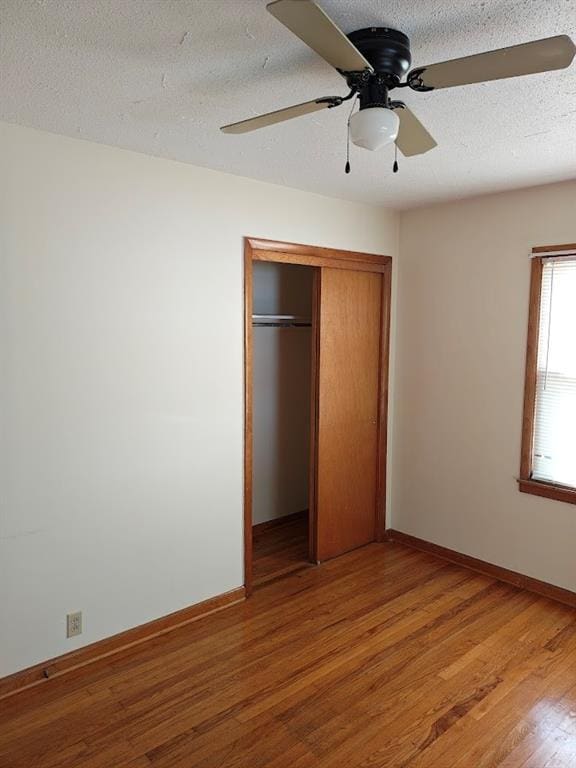 517 1st St, Platte City, MO 64079 - unfurnished bedroom with baseboards, a textured ceiling, ceiling fan, light wood-style flooring, and a closet