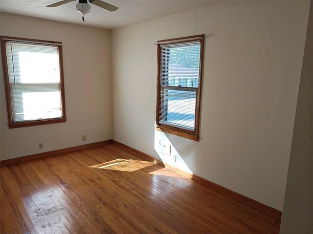 unfurnished room with ceiling fan, a textured ceiling, and hardwood / wood-style floors