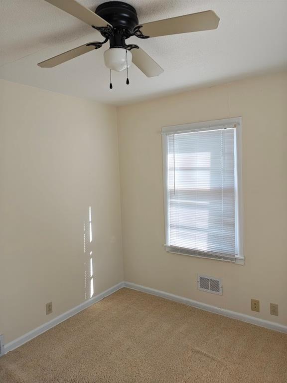 517 1st St, Platte City, MO 64079 - unfurnished room featuring light carpet, baseboards, ceiling fan, and visible vents