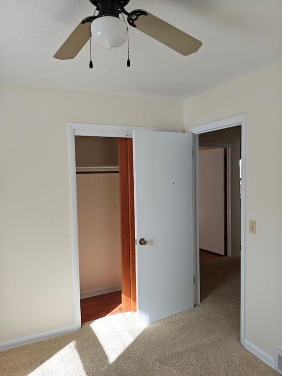 unfurnished bedroom featuring a closet, ceiling fan, and carpet floors