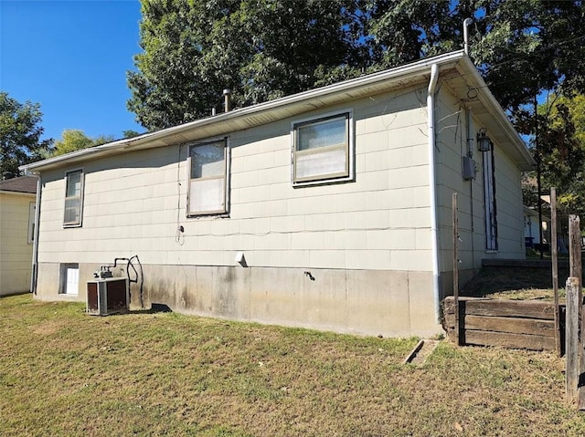 view of property exterior with central AC unit and a yard