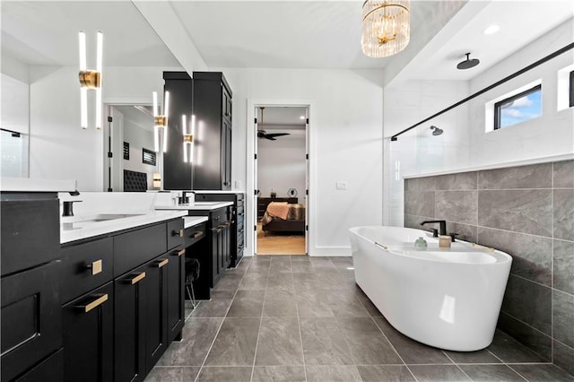 bathroom with separate shower and tub, vanity, tile walls, tile patterned flooring, and a chandelier