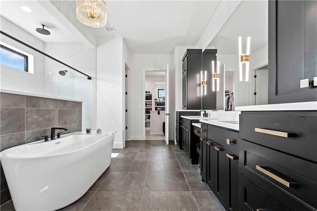 bathroom with tile patterned flooring, separate shower and tub, vanity, and tile walls