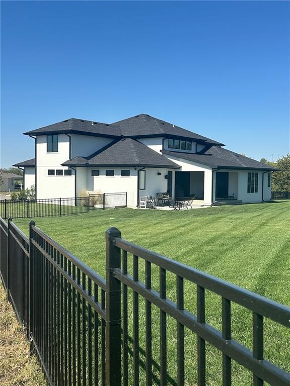 back of house featuring a patio and a yard