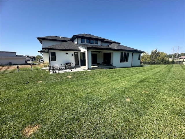 back of house featuring a lawn and a patio area