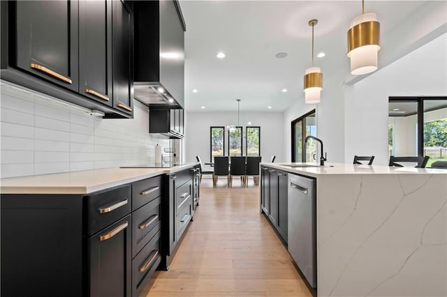 kitchen featuring light wood-type flooring, hanging light fixtures, and a healthy amount of sunlight