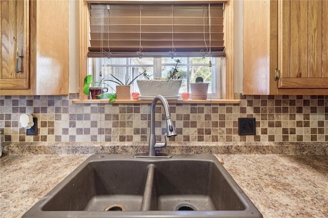 room details with light stone countertops, sink, and tasteful backsplash