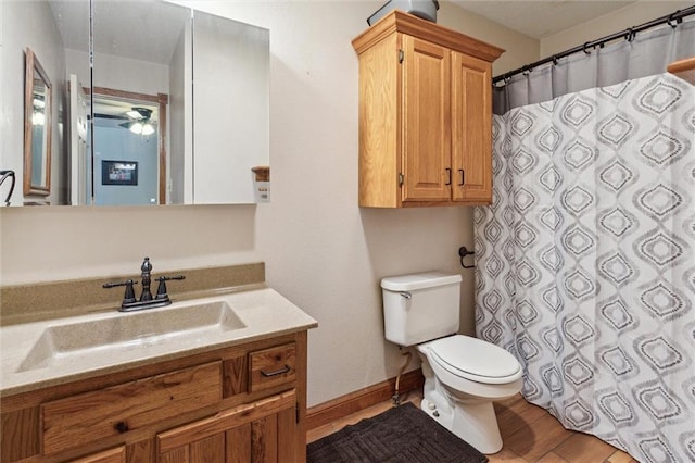 bathroom featuring ceiling fan, vanity, hardwood / wood-style floors, and toilet