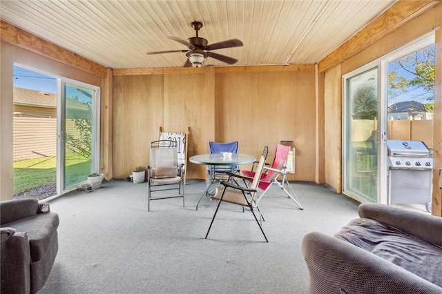 sunroom / solarium with ceiling fan, wood ceiling, and a wealth of natural light