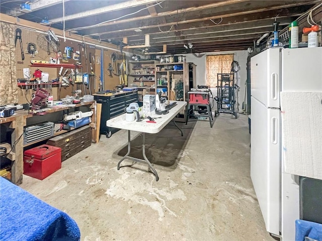 basement with a workshop area and white fridge