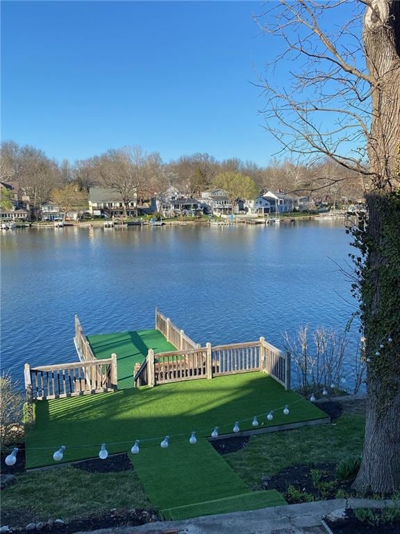 dock area featuring a water view and a lawn