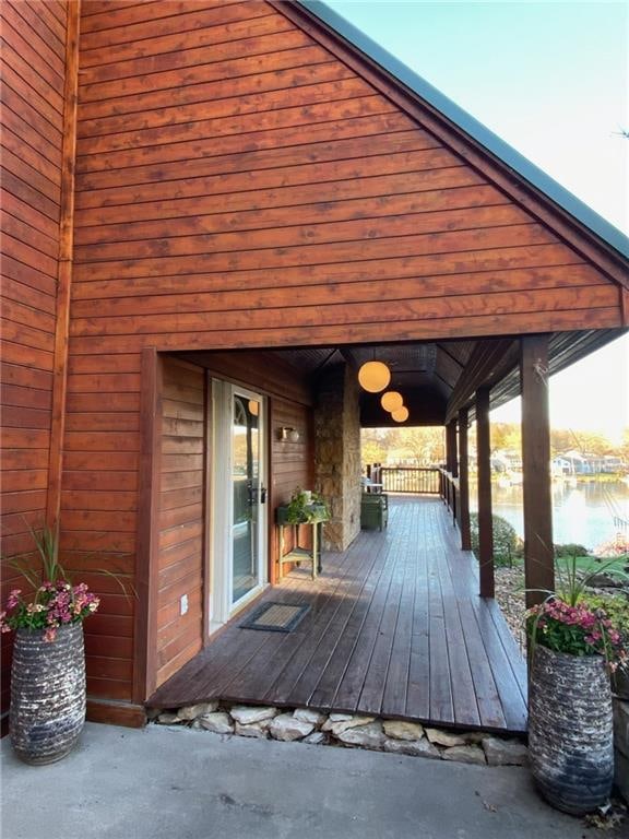 deck with a water view and covered porch