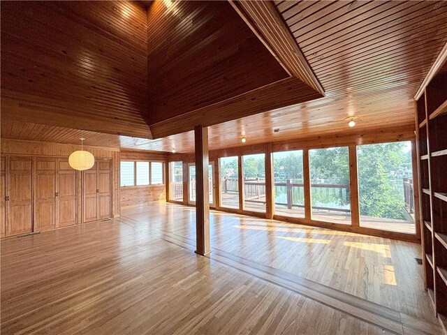 27 Beach Dr, Lake Tapawingo, MO 64015 - unfurnished living room featuring wooden walls, light wood-style floors, and wooden ceiling