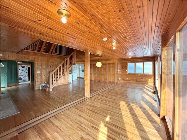 27 Beach Dr, Lake Tapawingo, MO 64015 - unfurnished living room featuring wooden walls, wooden ceiling, wood finished floors, and stairs
