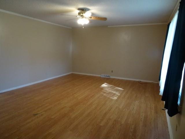 empty room featuring ceiling fan, hardwood / wood-style flooring, and crown molding