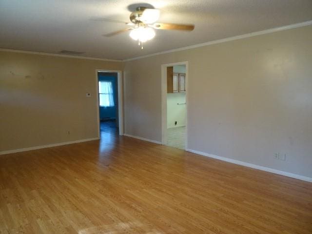 spare room with ornamental molding, light wood-type flooring, and ceiling fan