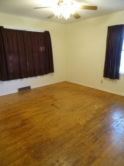 empty room featuring wood-type flooring and ceiling fan