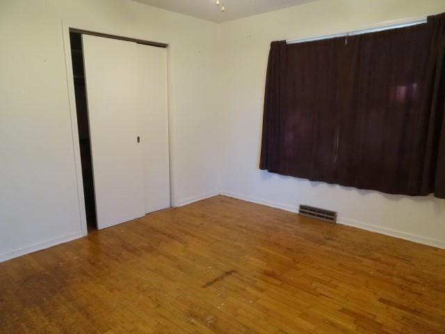 unfurnished bedroom with hardwood / wood-style floors and a closet