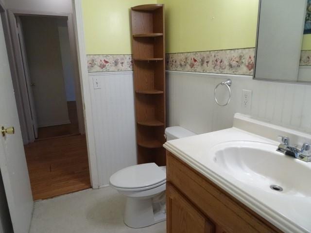 bathroom featuring wood-type flooring, vanity, and toilet