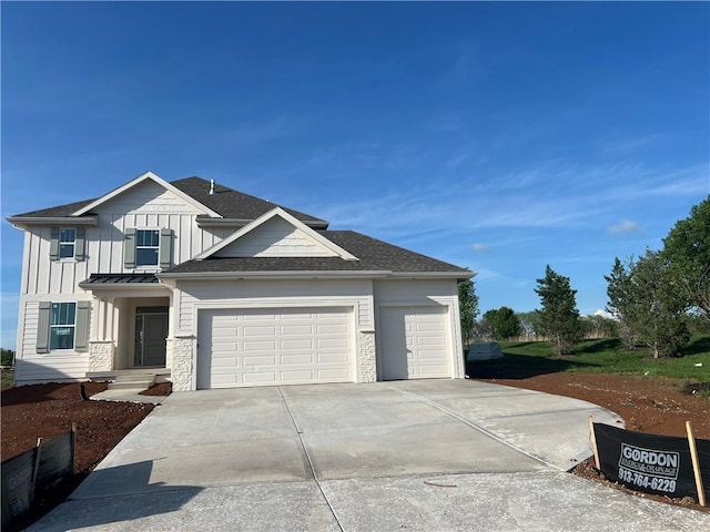 2202 W 178th Ter, Overland Park, KS 66085 - view of front of property with board and batten siding, a garage, concrete driveway, roof with shingles, and stone siding