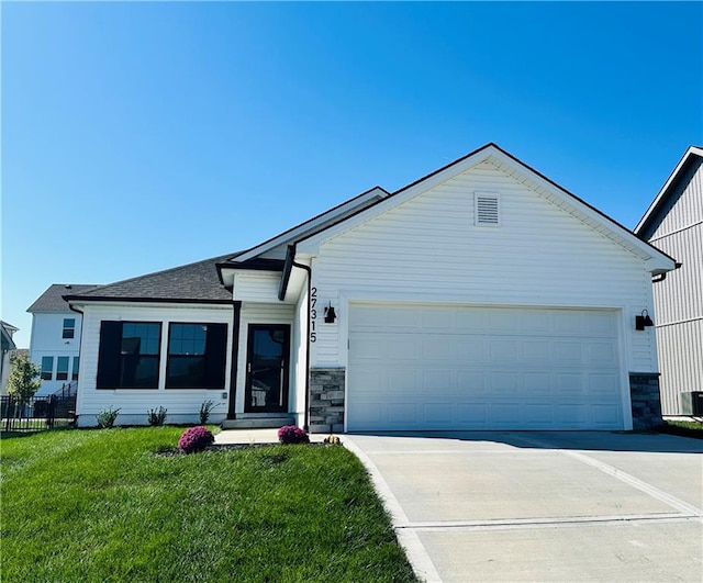 view of front of home with a garage and a front lawn