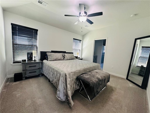 carpeted bedroom featuring vaulted ceiling, multiple windows, ensuite bathroom, and ceiling fan