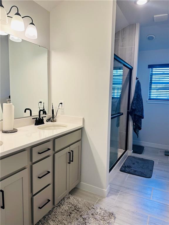 bathroom with vanity, hardwood / wood-style floors, and a shower with door