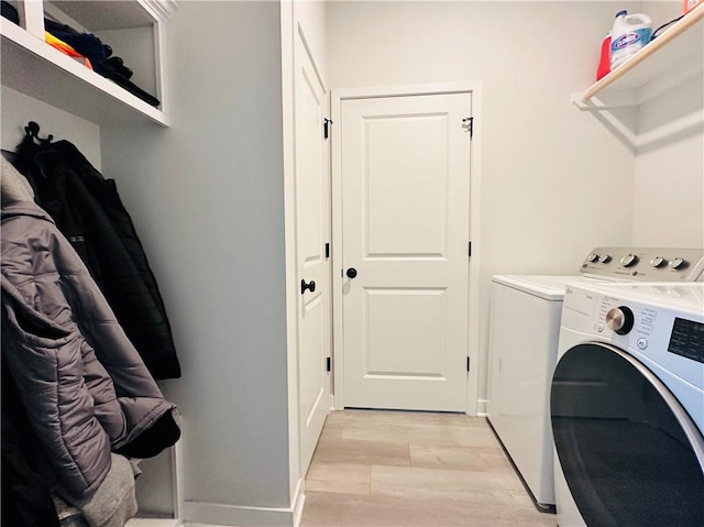 clothes washing area with light hardwood / wood-style floors and independent washer and dryer