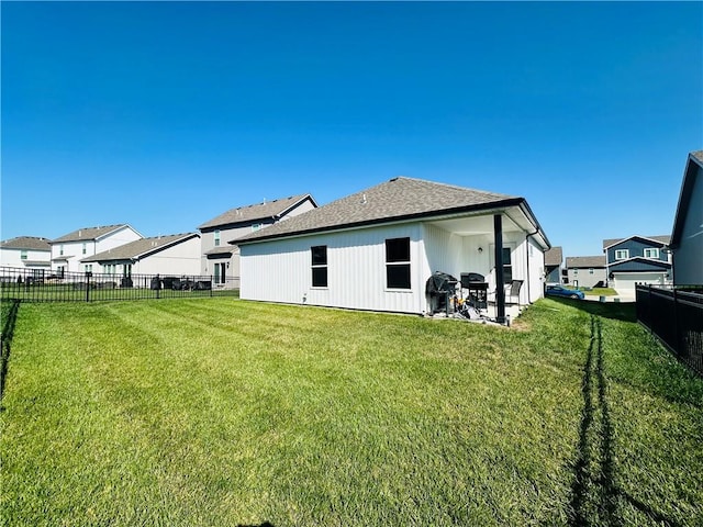 rear view of house with a patio and a yard