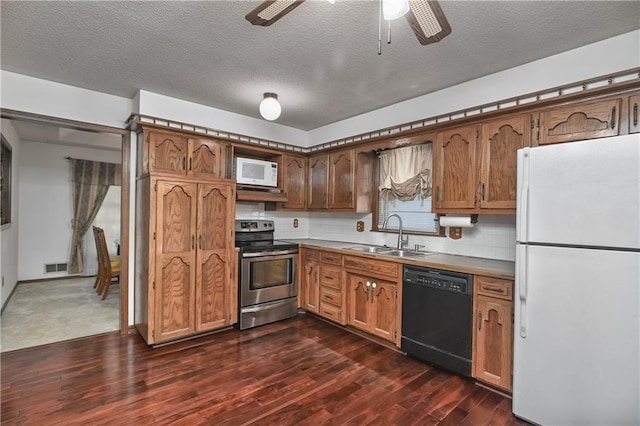 kitchen with dark hardwood / wood-style floors, sink, a textured ceiling, white appliances, and ceiling fan