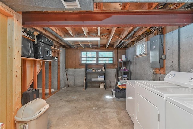 basement featuring electric panel and washing machine and clothes dryer