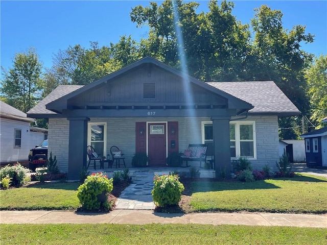 view of front of home with a porch and a front lawn