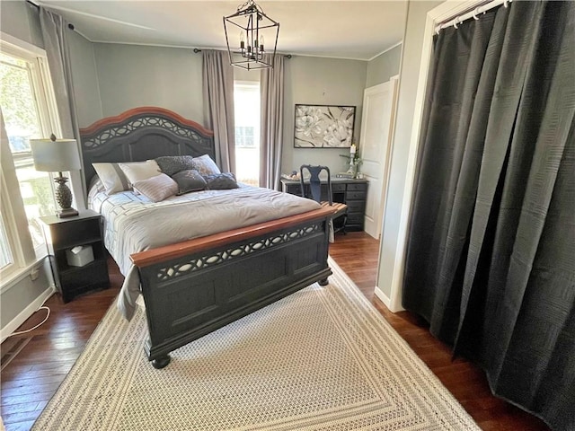 bedroom featuring an inviting chandelier and dark wood-type flooring