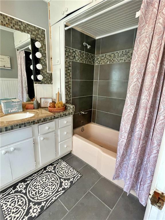 bathroom with shower / bath combo, vanity, and tile patterned floors