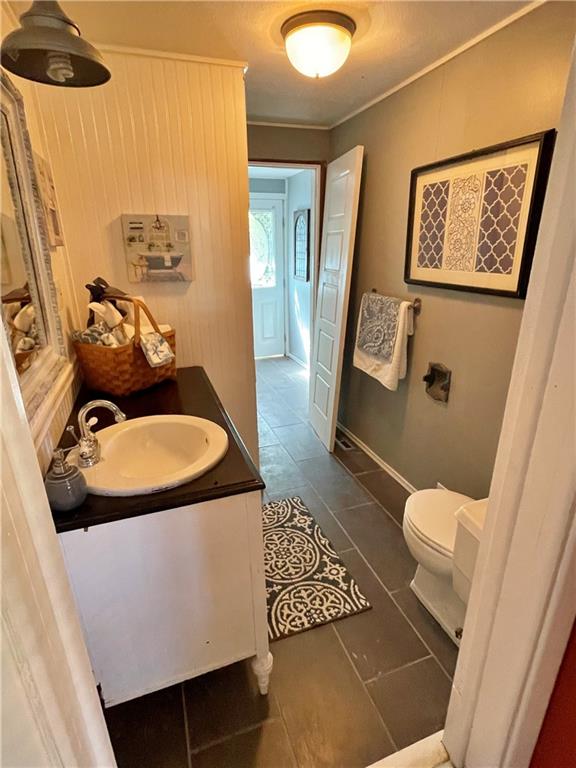 bathroom with ornamental molding, vanity, toilet, and tile patterned floors