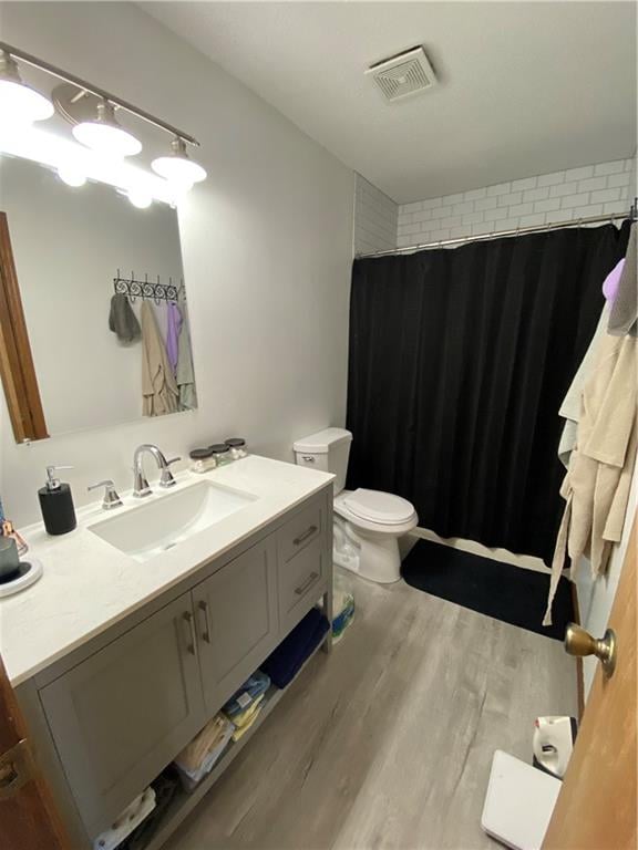 111 W 9th St, Maryville, MO 64468 - bathroom with curtained shower, vanity, toilet, and hardwood / wood-style flooring