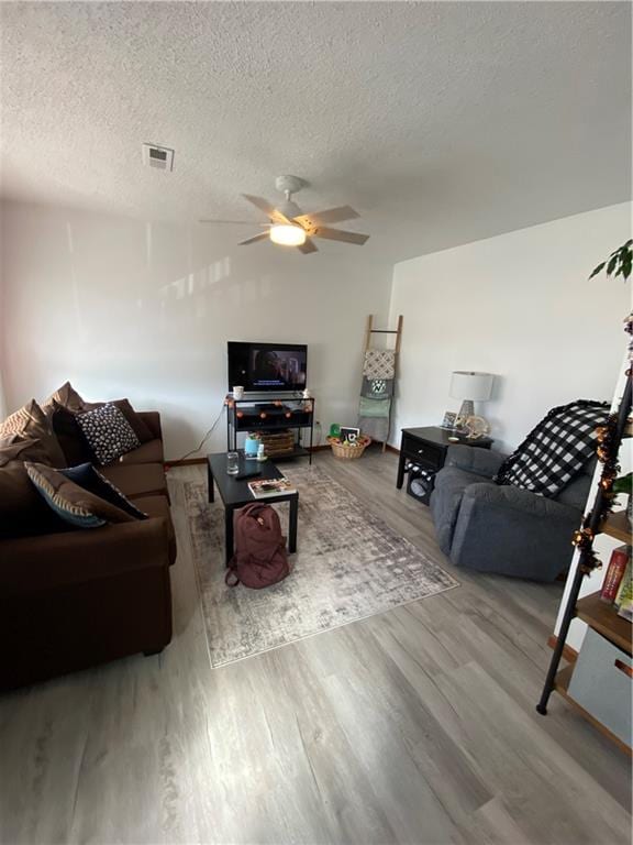 111 W 9th St, Maryville, MO 64468 - living room featuring a textured ceiling, light wood-type flooring, and ceiling fan