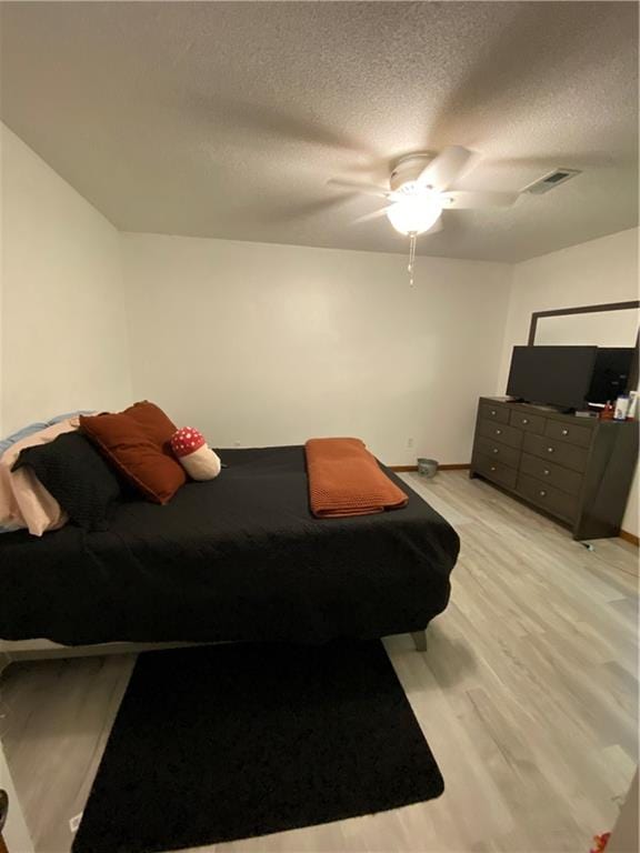 111 W 9th St, Maryville, MO 64468 - bedroom featuring a textured ceiling, ceiling fan, and light hardwood / wood-style flooring