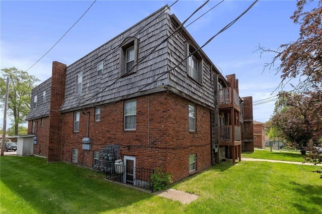 view of property exterior with a yard and a balcony