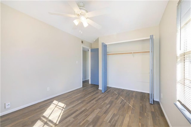 unfurnished bedroom with ceiling fan, dark wood-type flooring, and a closet