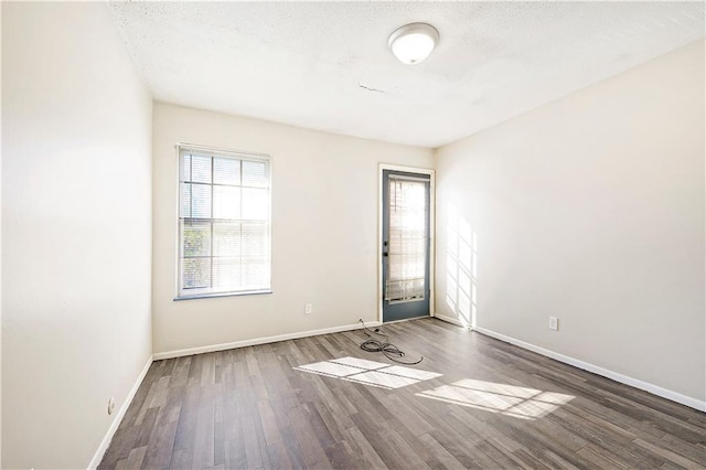 empty room featuring dark hardwood / wood-style flooring and a textured ceiling