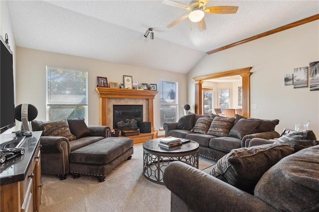 carpeted living room with decorative columns, a wealth of natural light, a fireplace, and lofted ceiling