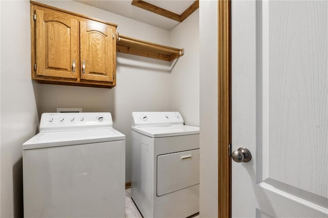 laundry room featuring washer and dryer and cabinets