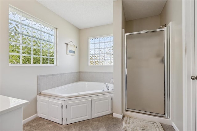 bathroom featuring separate shower and tub and a textured ceiling