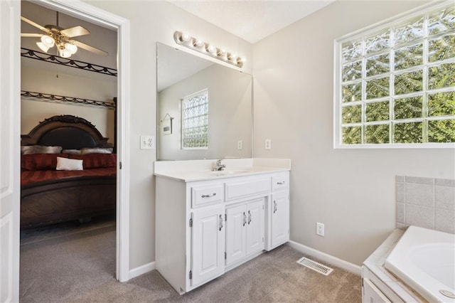 bathroom with vanity, ceiling fan, and a tub